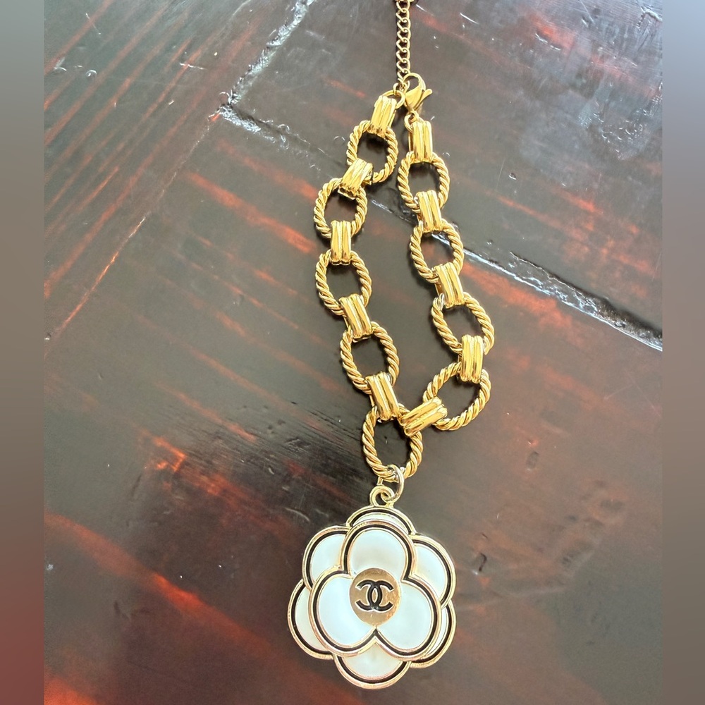 Chanel EUC Gold Tone bracelet
Camellia Enamel 3D charm on 7” 
Stainless Figaro
